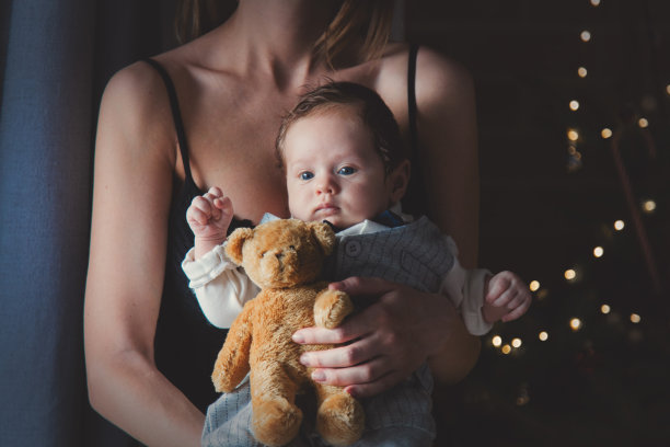 小婴儿的照片在妈妈的手中与泰迪熊玩具图片下载