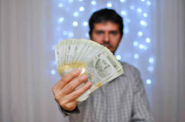 男人抱着一堆钱，事业和成功的观念图片下载