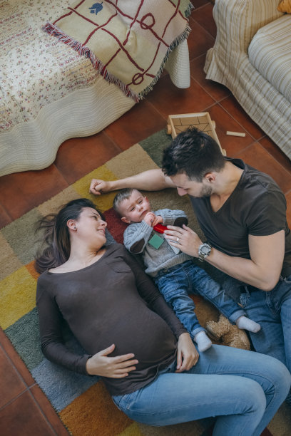 父母和他们可怜的小儿子在客厅里玩图片下载