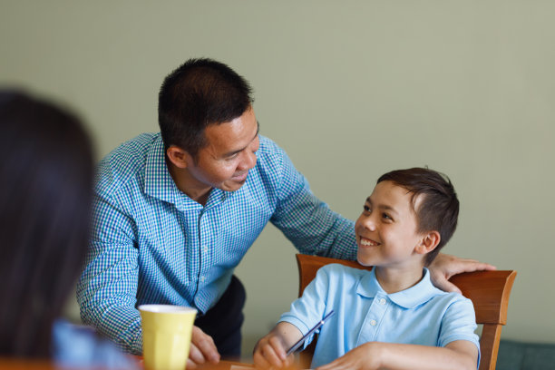 父亲帮助孩子放学后做作业图片下载