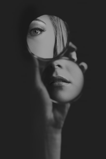 女人在小镜子里看自己的眼睛和嘴巴（艺术转换）素材图片
