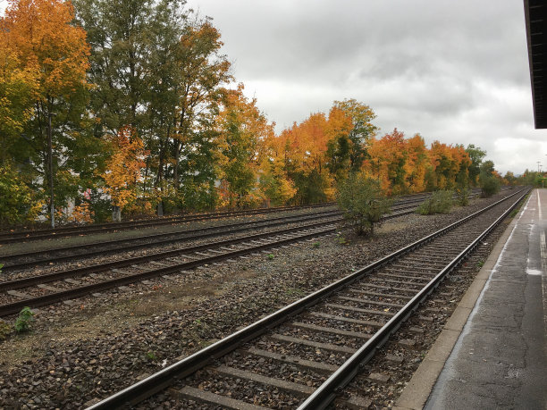 日落时分美丽天空映衬下的火车站。工业景观有铁路，色彩斑斓的多云蓝天。铁路枕木。铁路枢纽。重工业。货物运输。旅游的背景图片下载