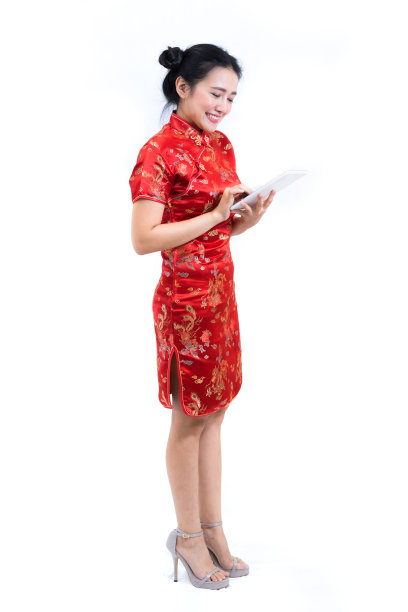 亚洲妇女的肖像穿着传统的中国长袍，旗袍，黑头发，使用平板电脑屏幕或应用程序的数字商业和技术概念图片下载