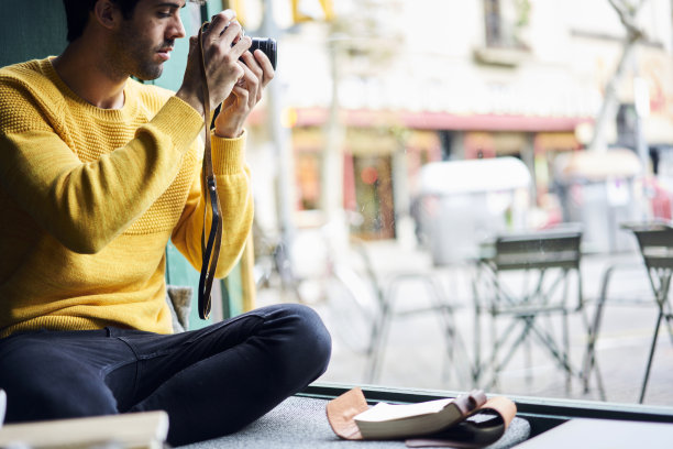 创造性的男性摄影师使用古董古董相机拍摄大都市的街道户外坐在咖啡店附近的窗户工作在时尚杂志复古风格的照片报道图片下载