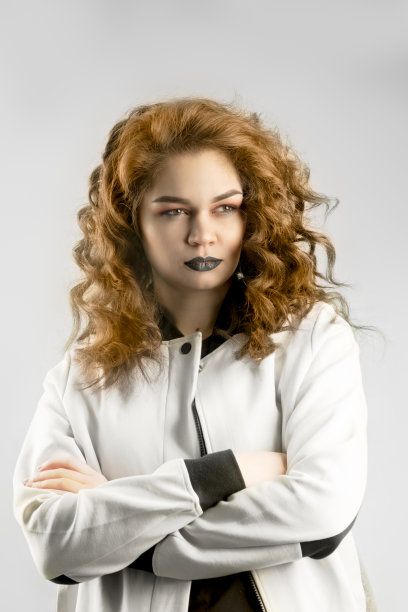 迷人美丽的肤色白种人女人严肃愤怒的脸看着与戏剧性的感觉交叉她的双手。展示你的产品。图片下载