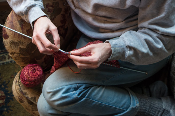 坐在扶手椅上编织的女人图片下载