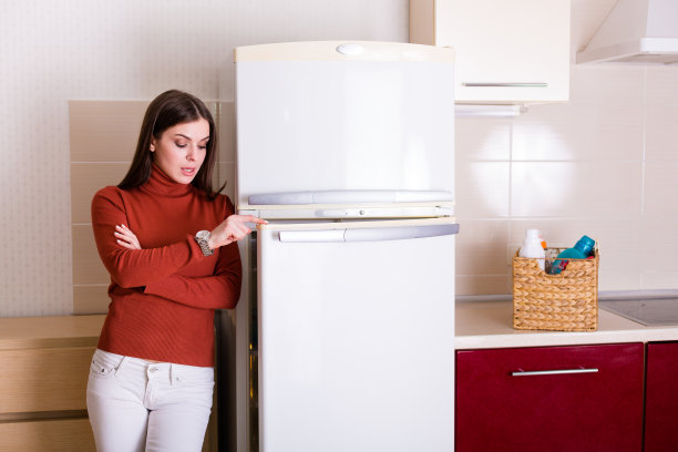 漂亮的年轻女子在打扫她公寓的厨房图片下载