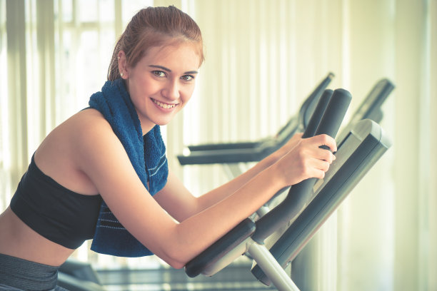 在健身房里锻炼的女人对着镜头微笑图片下载