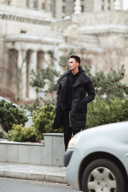 时尚的男人走在街上。冬天冷。大夹克配白色运动鞋。长途跋涉背景街。Profecional模型照片。图片下载