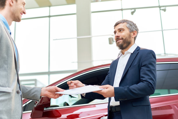 英俊的汽车销售员给客户合同图片下载