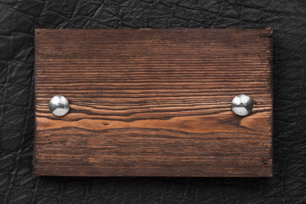 框架、边框由木头制成，用铁铆钉固定在黑色皮革上，孤立在白色背景上。图片下载