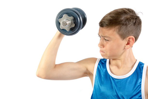 一个十几岁的男孩在用哑铃图片下载