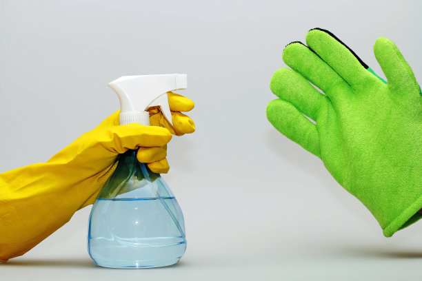 他手里拿着一个瓶子，戴着黄色手套，拿着一块清洁海绵图片下载