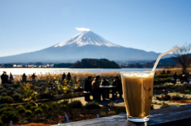 近距离的冰咖啡在木地板与富士山的背景。图片下载