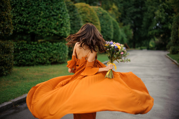 后面的观点，有吸引力的女人在长橙色连衣裙图片下载