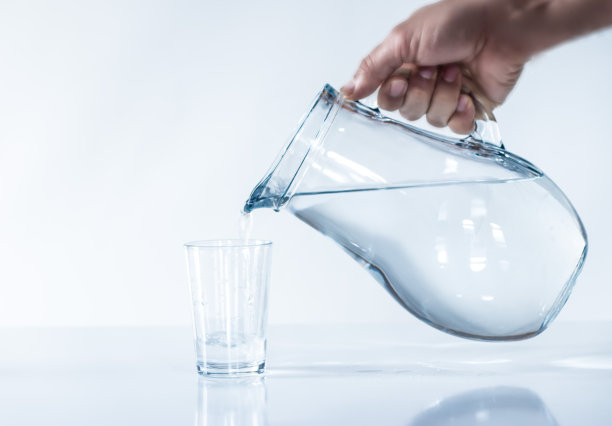 这个男人正在给水杯注水。博士İNK水。图片下载