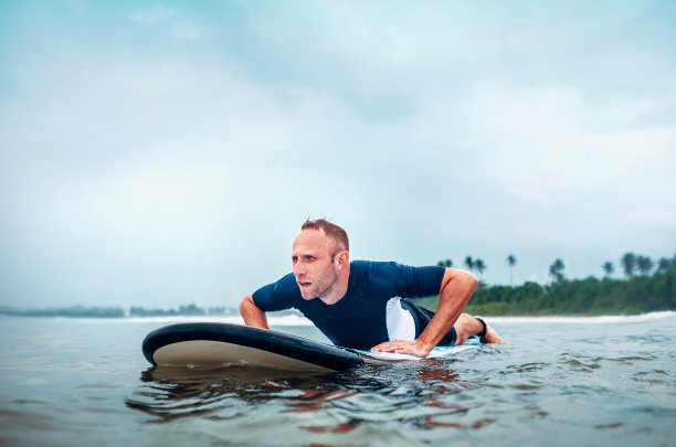 冲浪者浮在冲浪板上，等待海浪图片下载