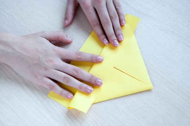 孩子们的手做成了一只黄色的纸船图片下载