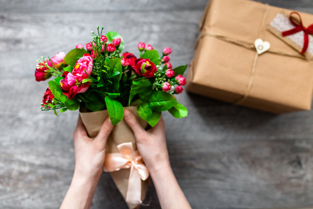 女人手里拿着包装好的礼物，情人节，浪漫的照片。浪漫的灰色木质背景，配爱心礼品，适合做广告图片下载