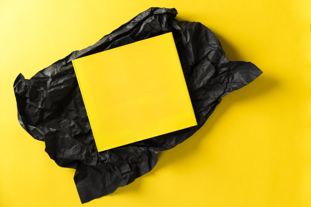 黄色的书，黑色包装纸，黄色背景图片下载