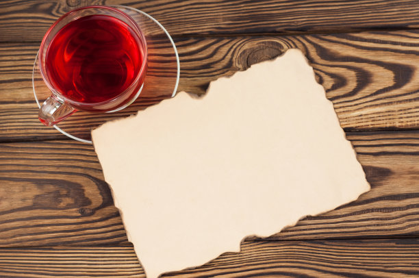 满杯红色美味的覆盆子茶和空白烧纸在旧的木制乡村桌子上图片下载