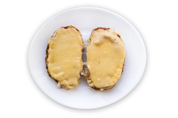 白盘子上放着恶心的三明治。不健康的早餐。孤立在白色背景上。图片下载