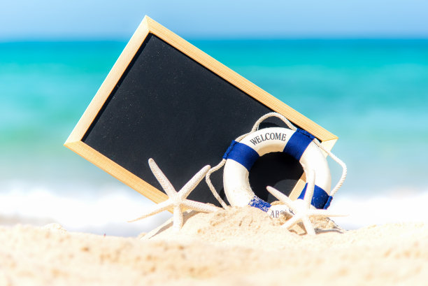 特写的黑板写，救生圈和海星在沙滩上的沙子。夏天的概念图片下载