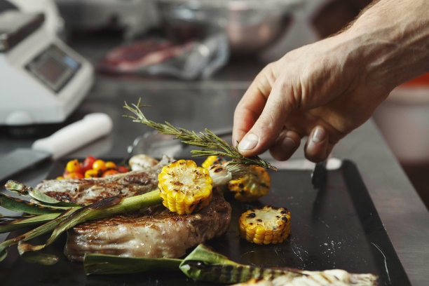 厨师在餐厅厨房烹饪多汁的牛排图片下载
