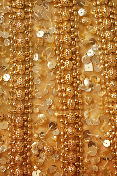 抽象背景与黄金亮片和珠子。有珠子和亮片的织物图片下载