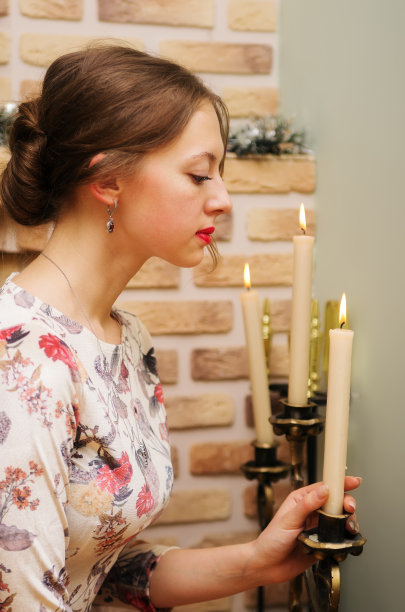 穿着漂亮衣服的女孩正对着烛台图片下载