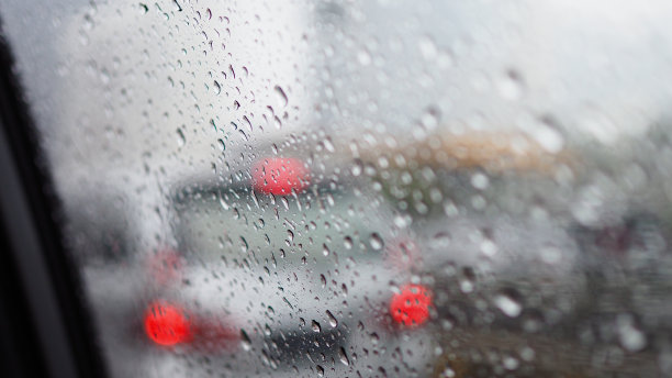 雨点落在车窗上，背景是车流。图片下载