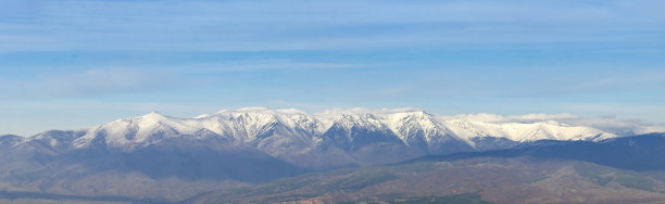全景式的山峰覆盖着积雪，空中泛起一片云雾图片下载