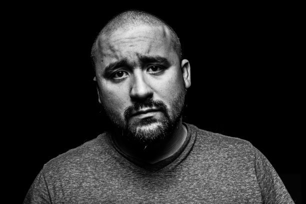 黑色背景下的沮丧男人。图片下载