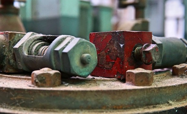 图像的旧机器齿轮与几个螺杆尺寸。废弃工厂里遗留下来的破旧的机器。老化设备的形象与生锈和齿轮部分。图片下载