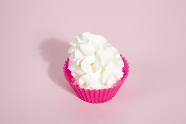 简单的粉色硅胶纸杯蛋糕模具和鲜奶油图片下载