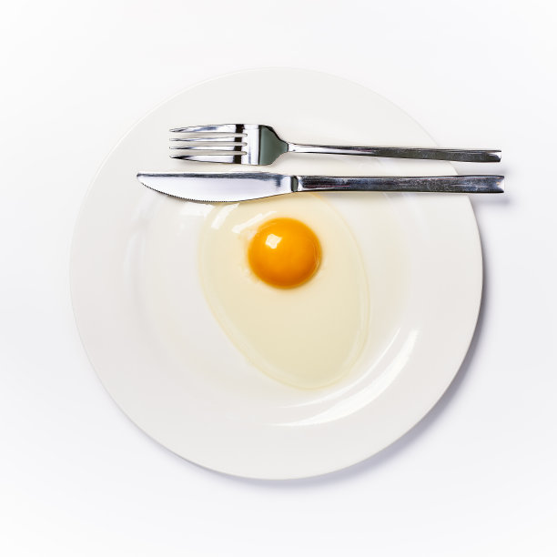 蛋黄放在白色的盘子上，放置在餐桌上图片下载