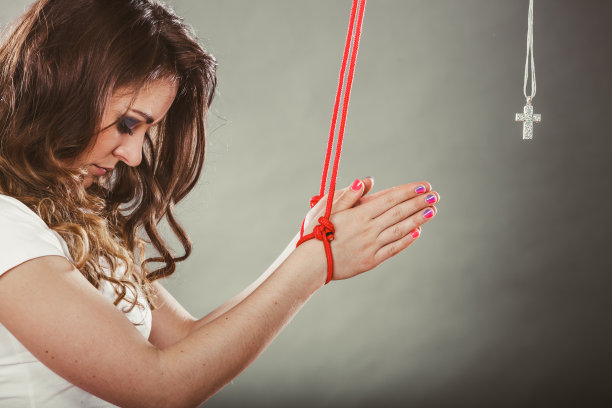 被绑的女人被迫祈祷。假的信仰。宗教。图片下载