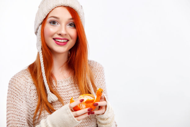 美丽的红发快乐的女人与圣诞普通话在白色的背景与拷贝空间。圣诞和新年海报。图片下载