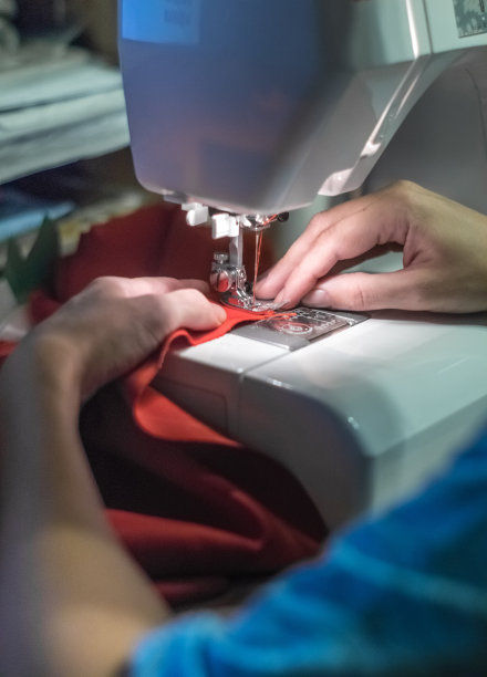 一双手在白色缝纫机上工作图片下载