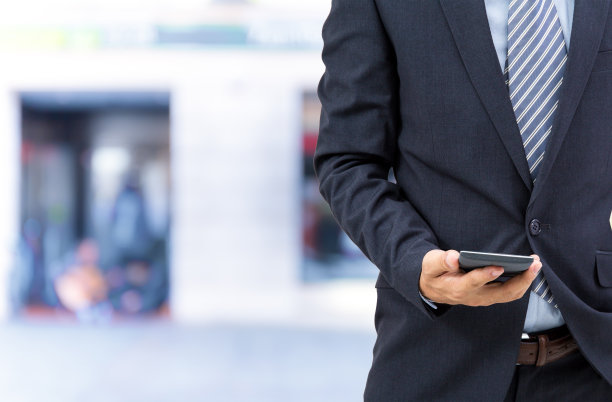孤立的商人在街上拿着智能手机图片下载