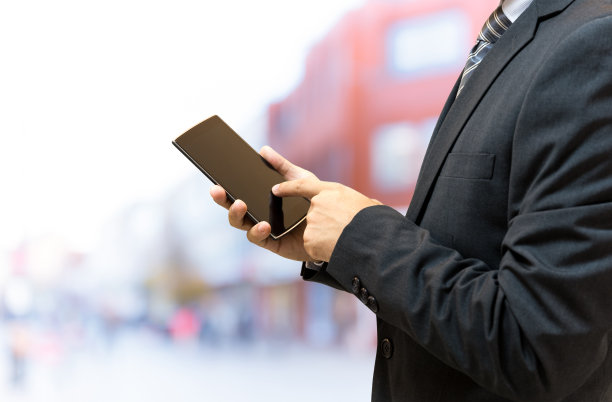 孤立的商人在街上拿着智能手机图片下载