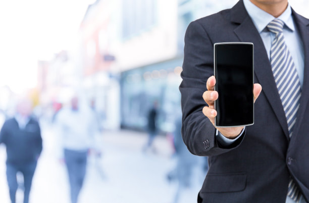 孤立的商人在街上拿着智能手机图片下载