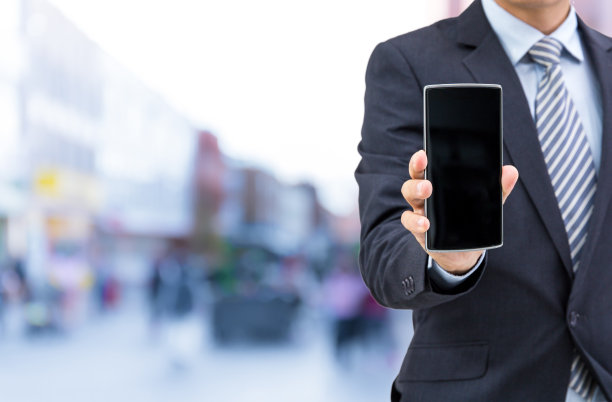 孤立的商人在街上拿着智能手机图片下载