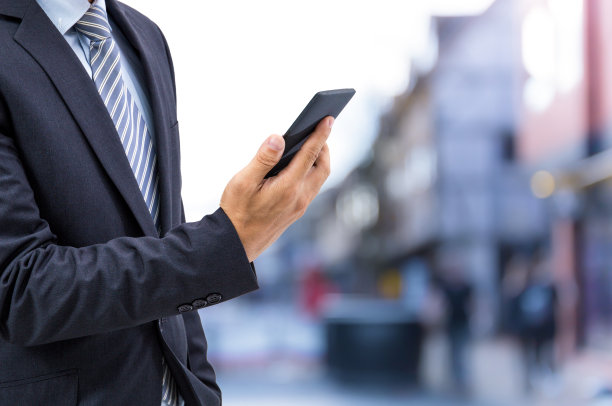 孤立的商人在街上拿着智能手机图片下载
