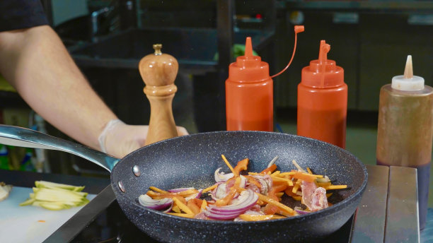 厨师用黄油在热煎锅上煎各种蔬菜和肉图片下载