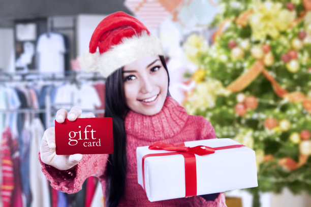 漂亮女孩展示礼品卡和礼盒图片下载