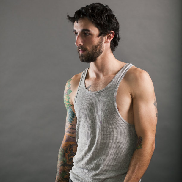 纹身的年轻人在灰色背心图片下载