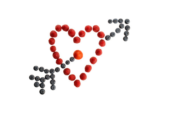 新鲜的浆果躺在一个心形孤立在白色图片下载