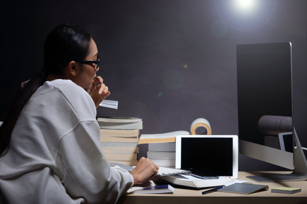 女孩穿着白衬衫读许多课本在桌子上堆放着许多高图片下载