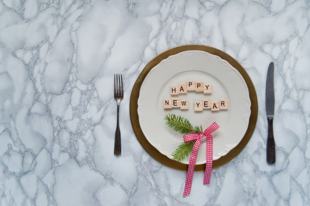 大理石桌子，表面有一个盘子和字母。新年祝福的概念。图片下载